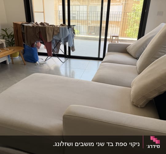סלון עם ספה ובגדים תלויים לייבוש